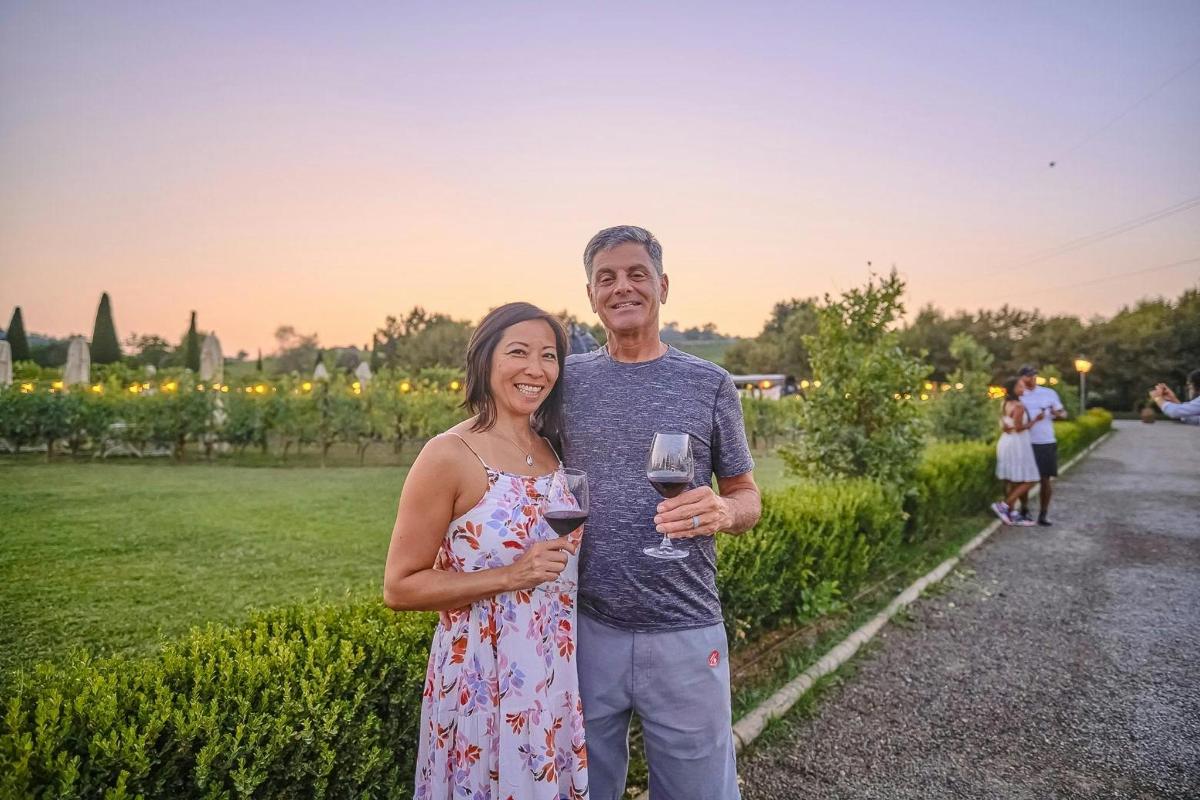 un uomo e una donna che tengono in mano un bicchiere di vino