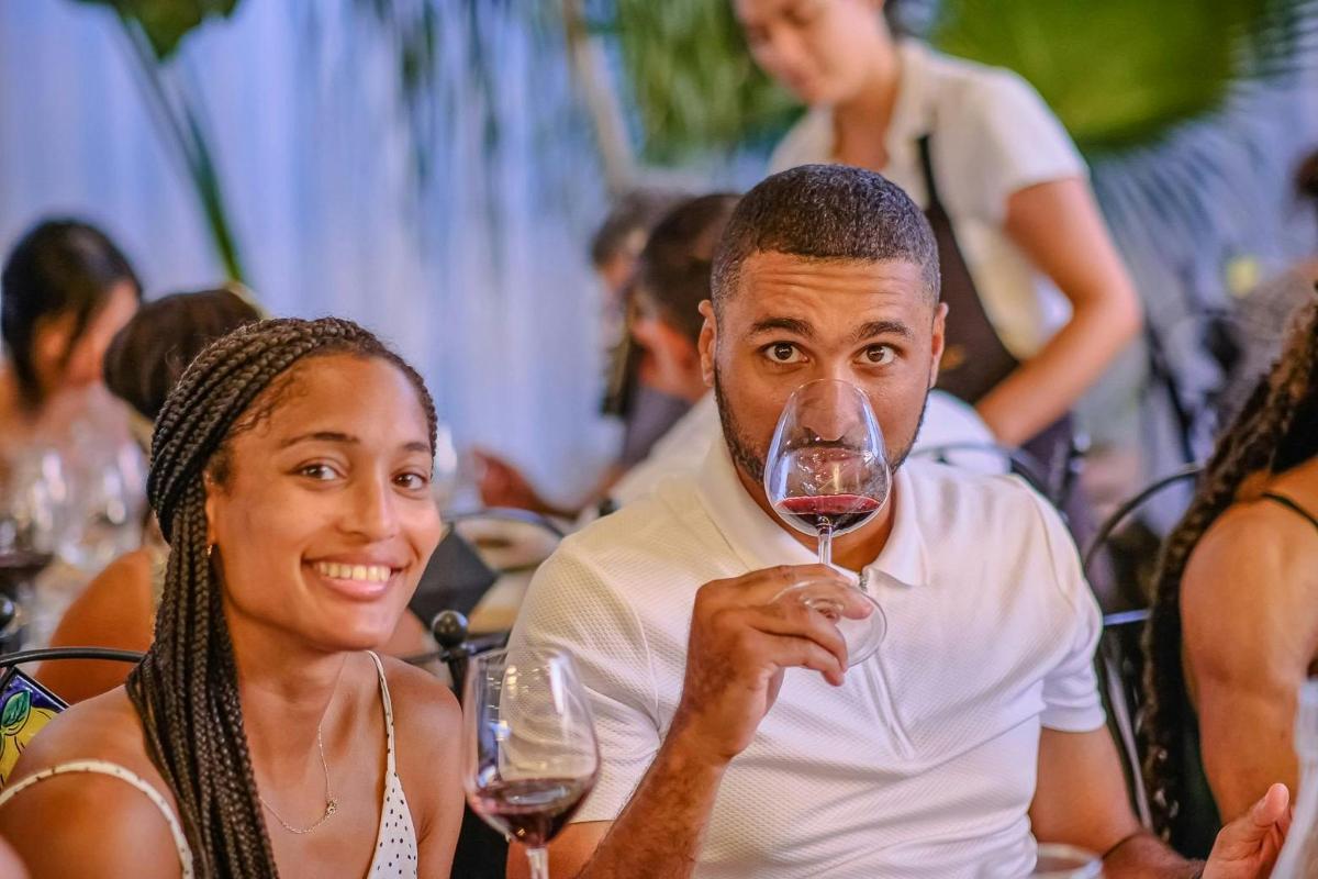 un uomo e una donna seduti a un tavolo che bevono vino