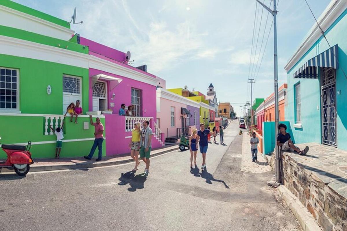 un gruppo di persone che camminano lungo una strada con edifici colorati