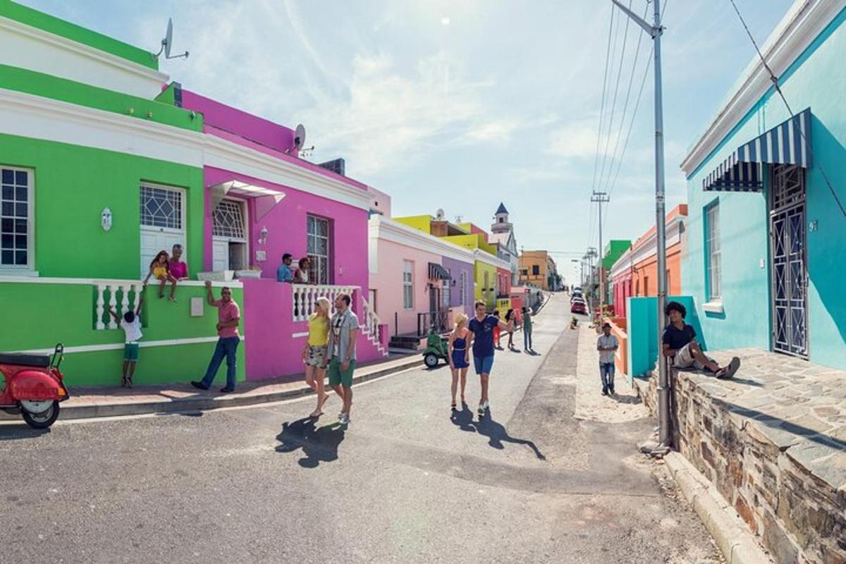 Un grupo de personas caminando por una calle con edificios coloridos.