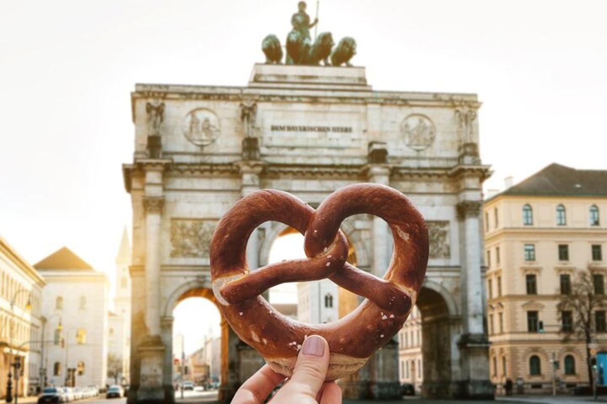 una persona sosteniendo un pretzel frente a un edificio