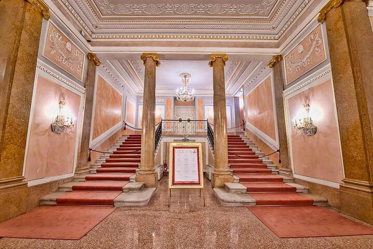 Una escalera en un edificio con pilares y un cuadro.