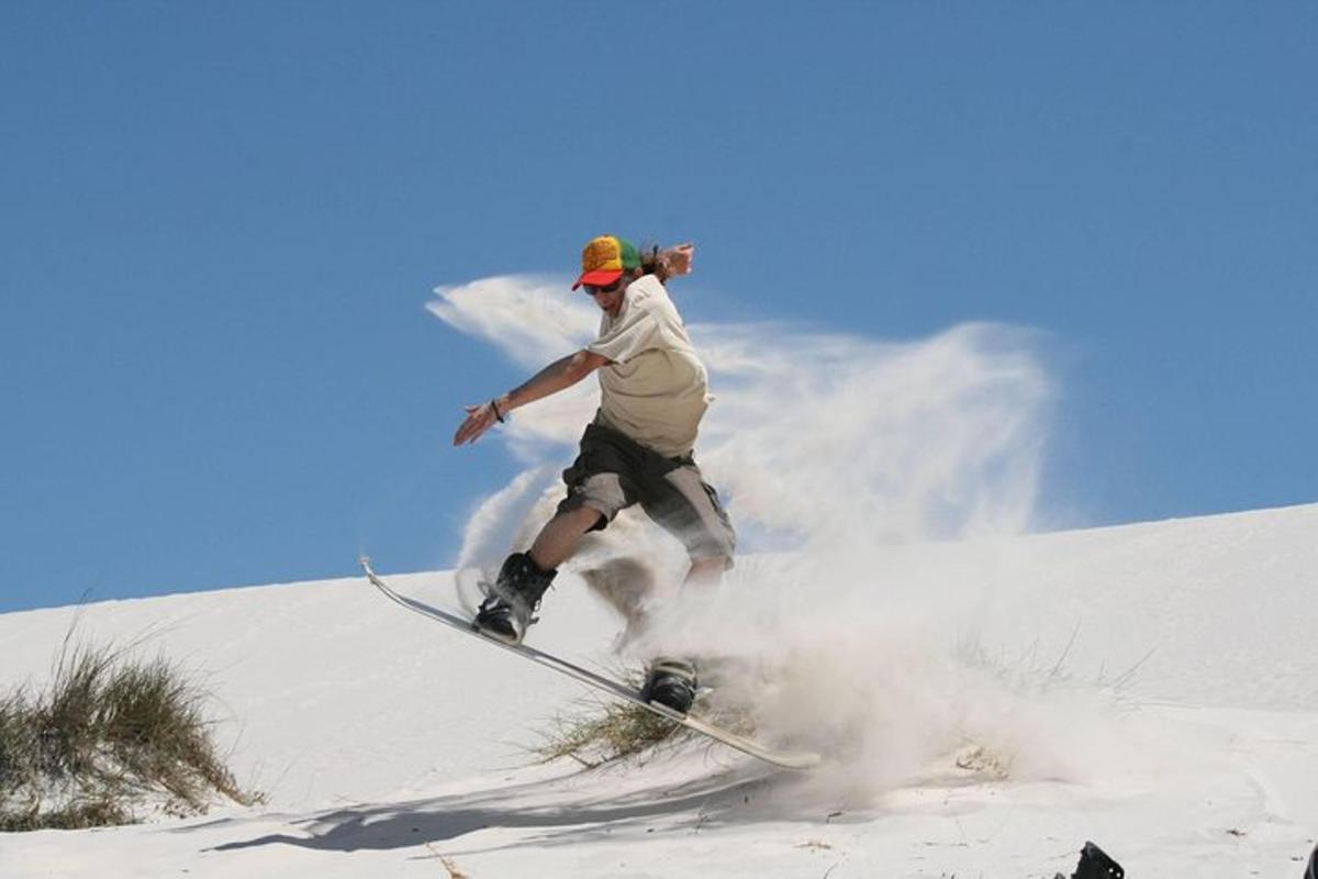 un bărbat care cobora cu un snowboard pe o pantă acoperită de zăpadă