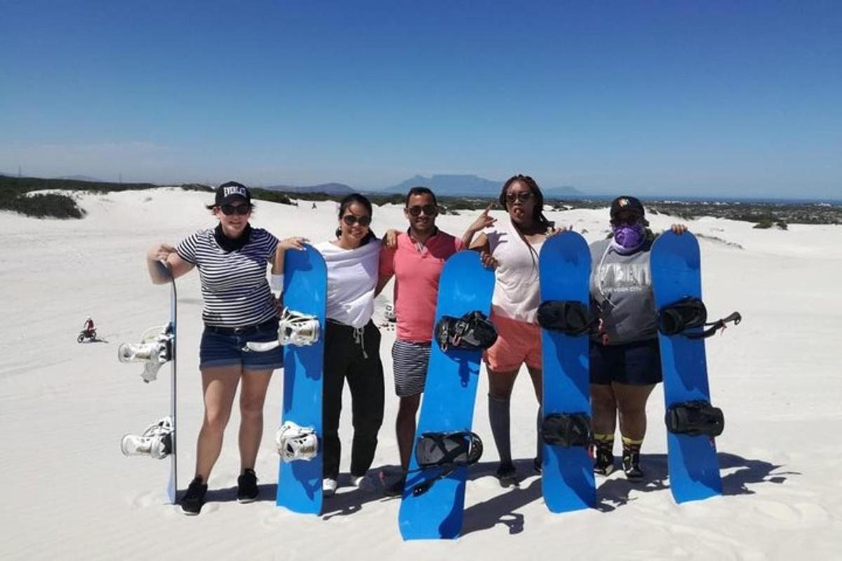 Un grupo de personas de pie en la playa con tablas de snowboard.