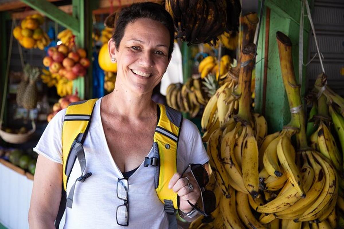 a woman standing in a market with a bunch of bananas
