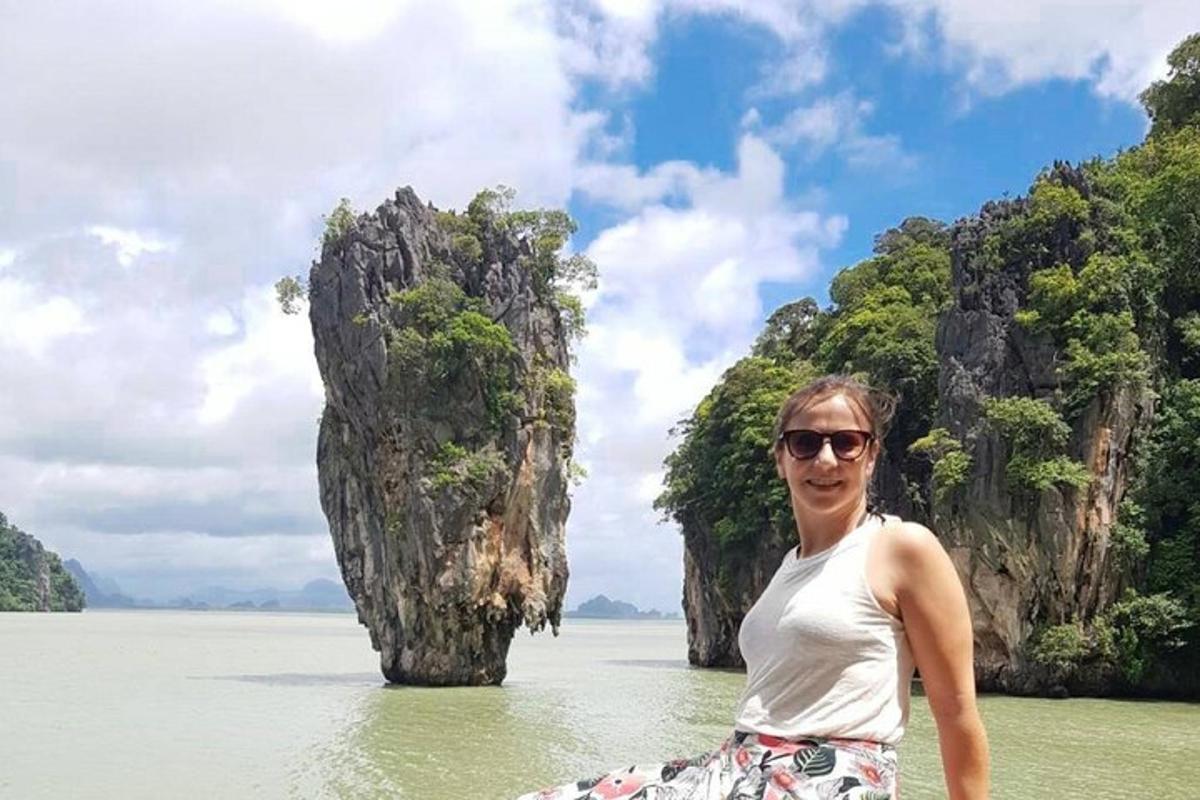 Un hombre parado en el agua frente a un grupo de islas.