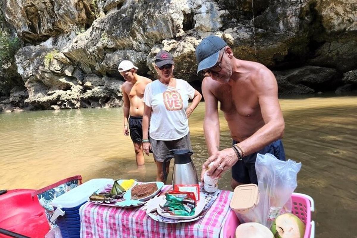 tři lidé stojící ve vodě poblíž piknikového stolu ve vodě