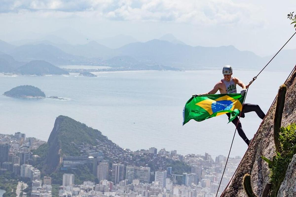 um homem em pé no topo de uma montanha segurando uma bandeira