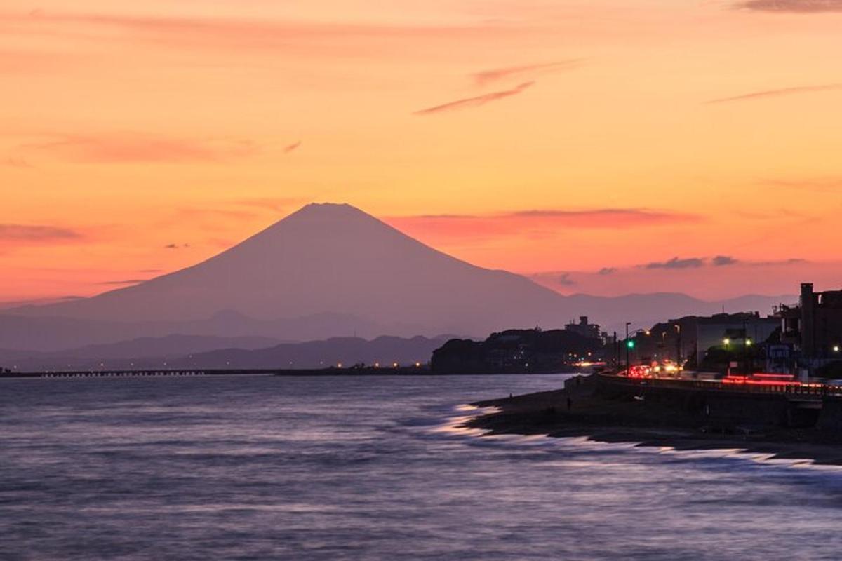 een uitzicht op een berg bij zonsondergang met het water