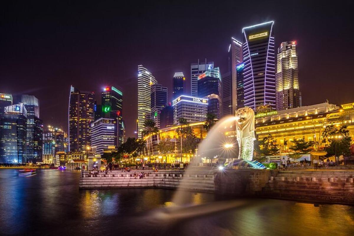 a fountain in front of a city at night