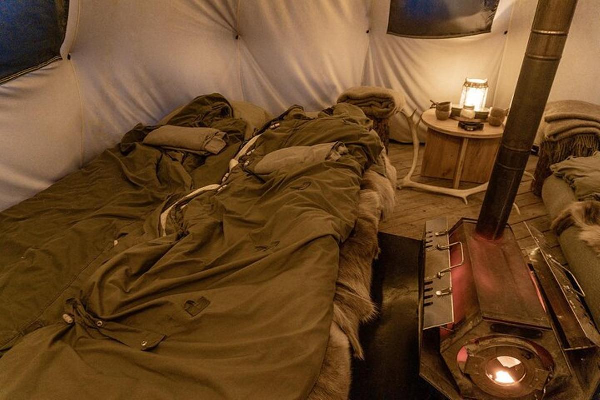 un letto in una tenda con una lampada e un tavolo