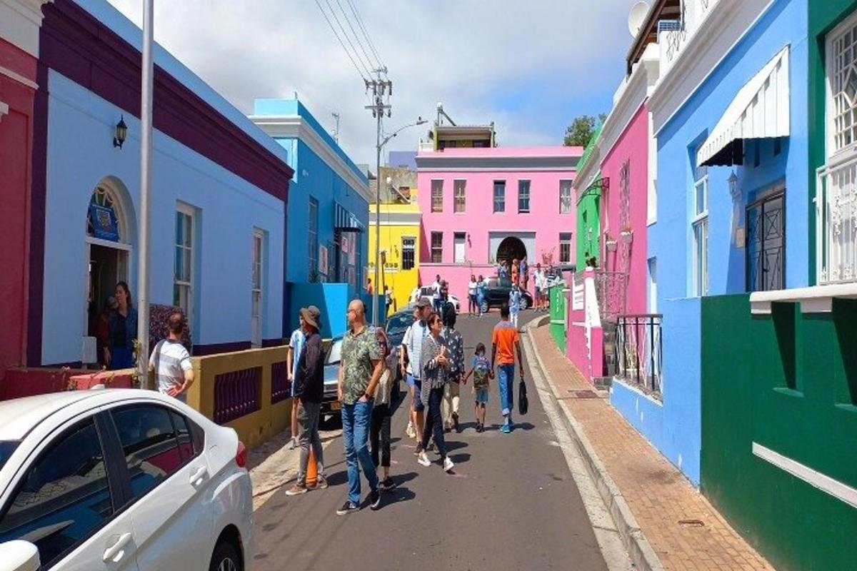 um grupo de pessoas caminhando por uma rua com prédios coloridos