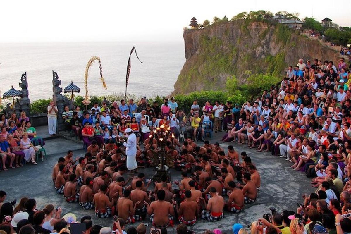 een grote menigte mensen die een ceremonie op het strand bekijkt