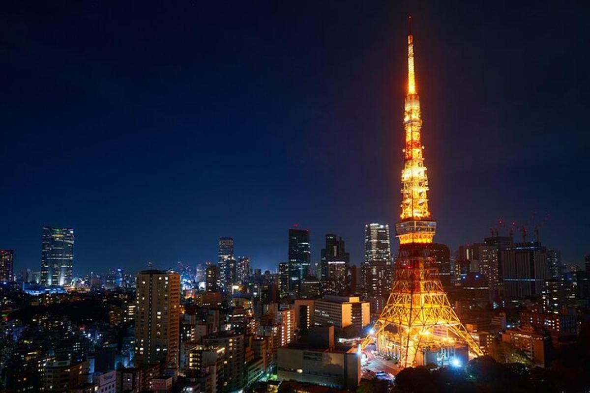 um horizonte de cidade à noite com uma torre iluminada