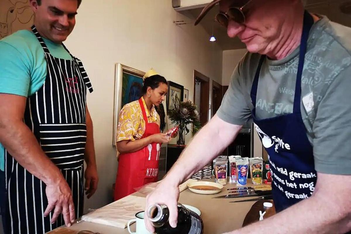 Dos hombres están de pie en una cocina preparando comida.