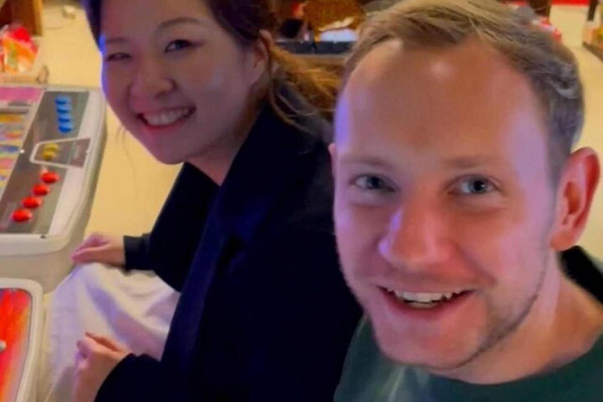 een man en een vrouw staan voor een koelkast