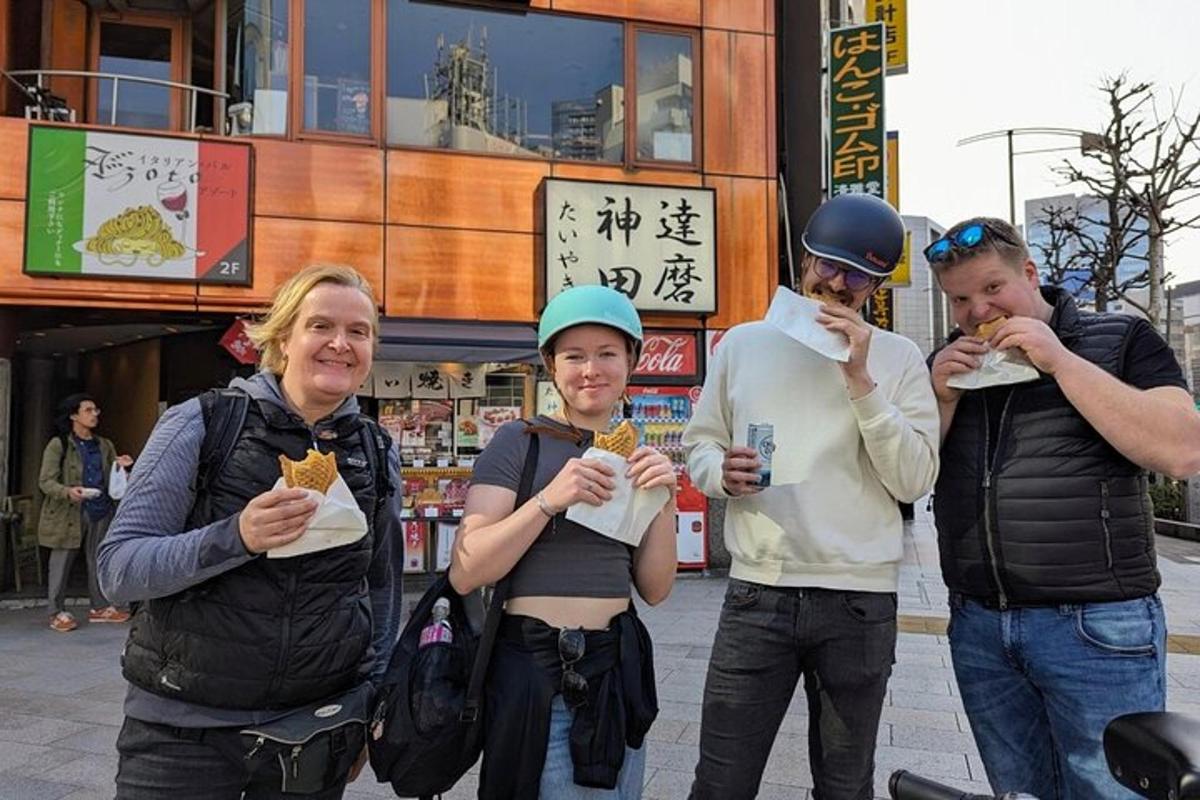 un gruppo di persone che mangiano cibo davanti a un edificio