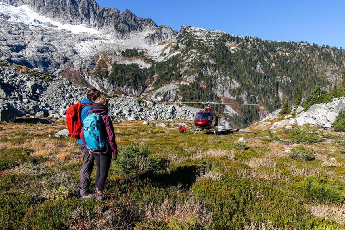 seseorang dengan beg galas dan helikopter di atas gunung