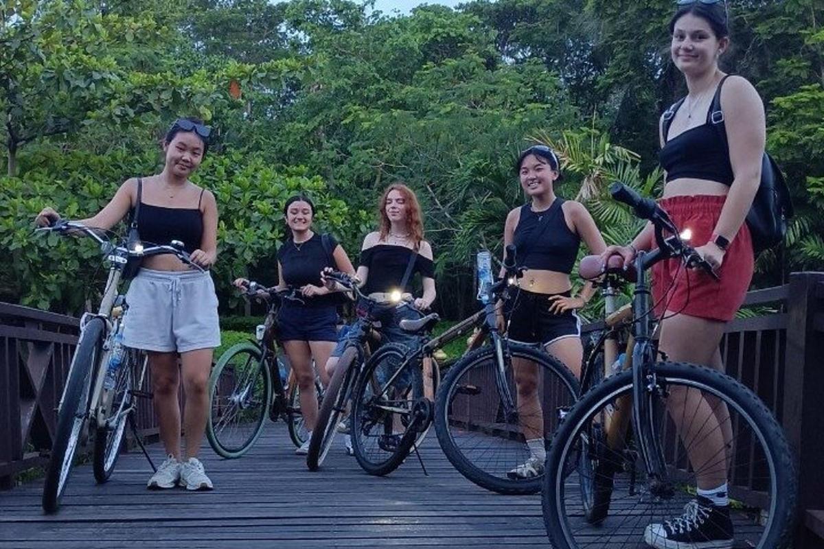 skupina žien stojacich na bicykloch na moste