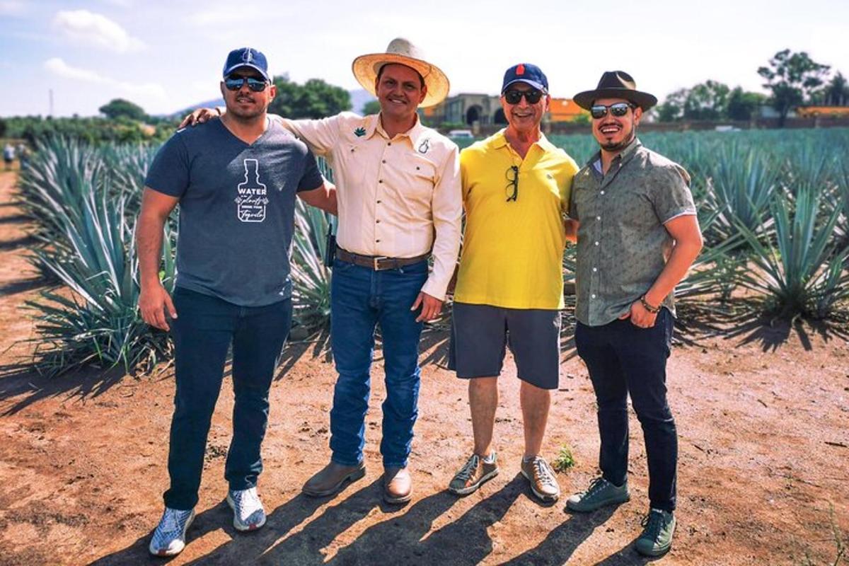 Un grupo de hombres de pie frente a una plantación de piñas.
