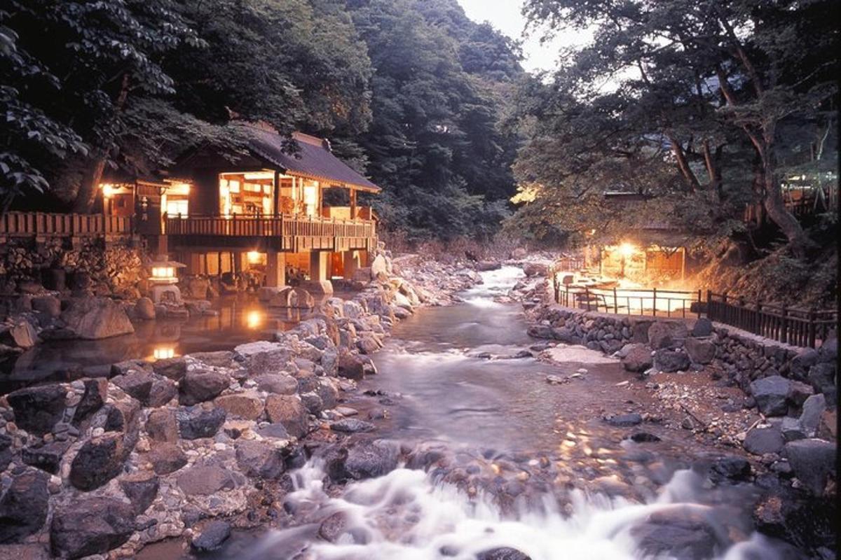 a river in front of a building with lights on