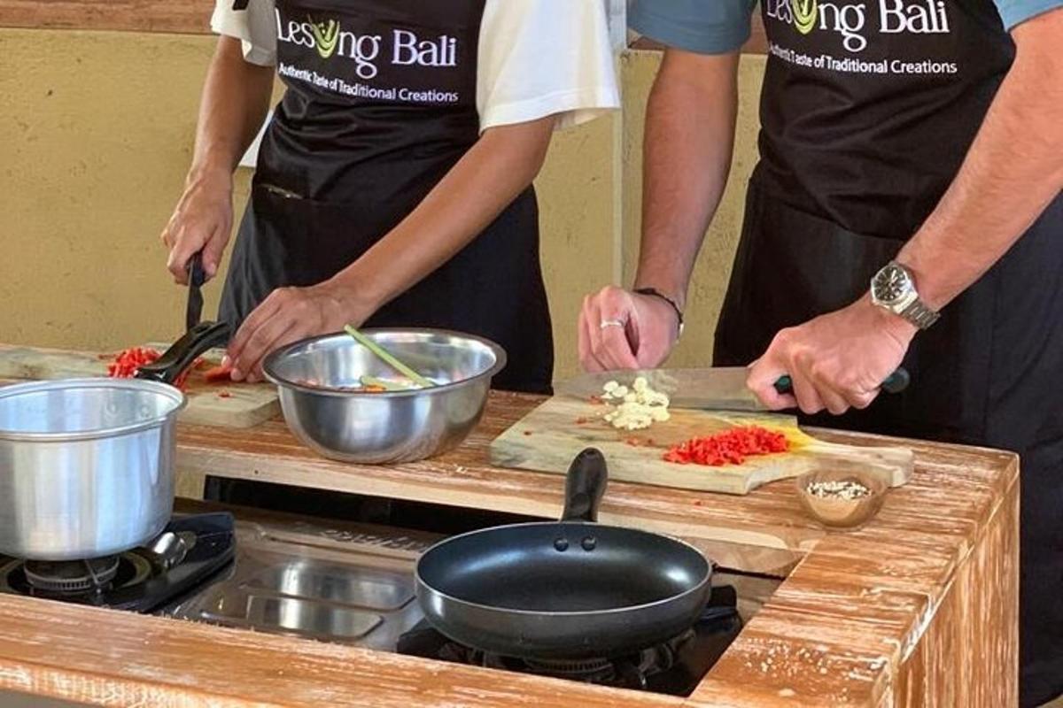 Dos personas en una cocina preparando comida en una tabla de cortar.