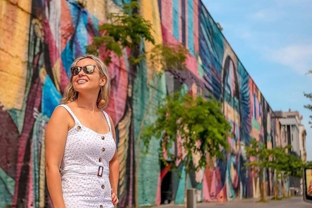 žena stojící před budovou s nástěnnou malbou