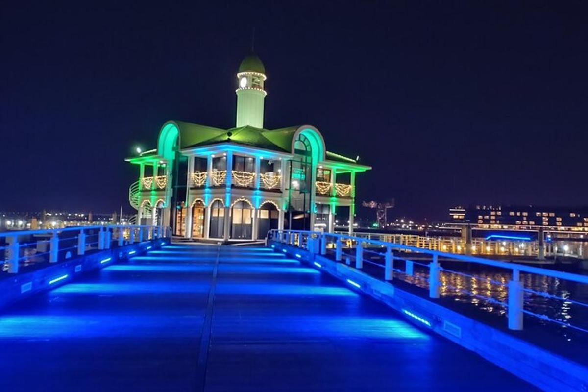 Un edificio en un muelle con luces azules por la noche.