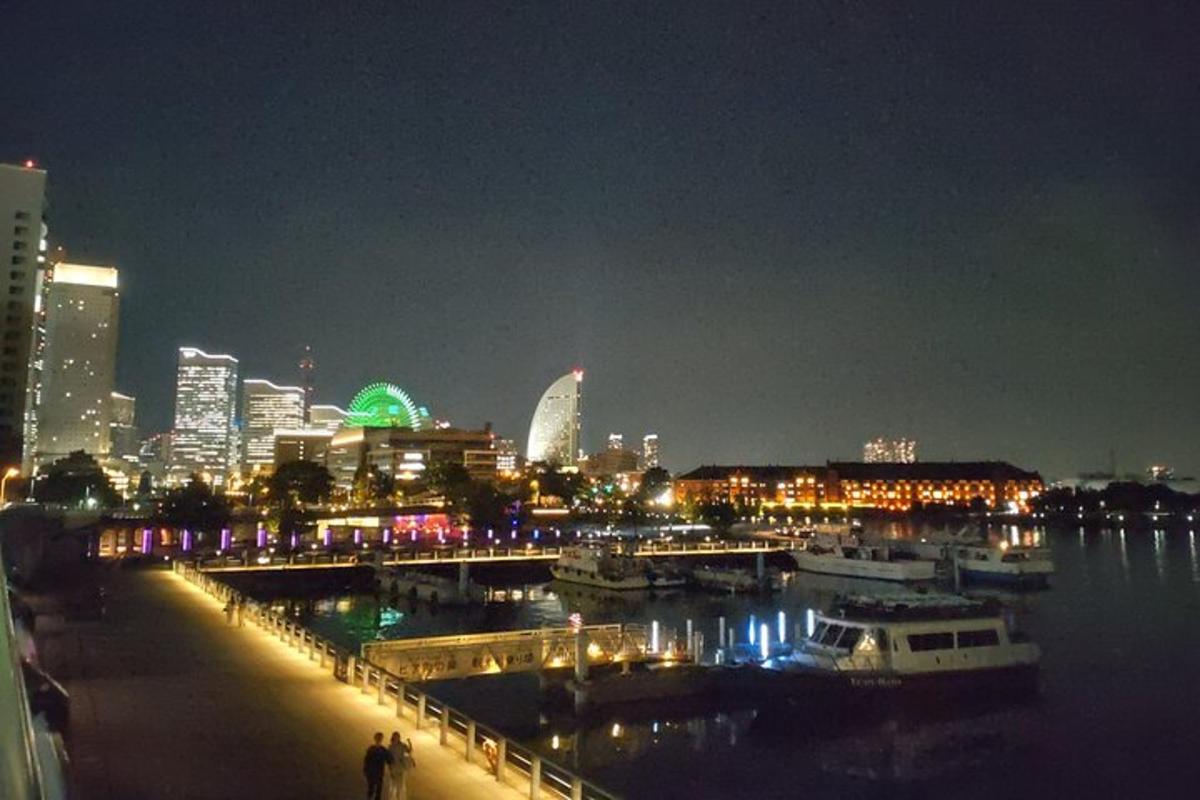 Un horizonte de la ciudad por la noche con barcos en el agua