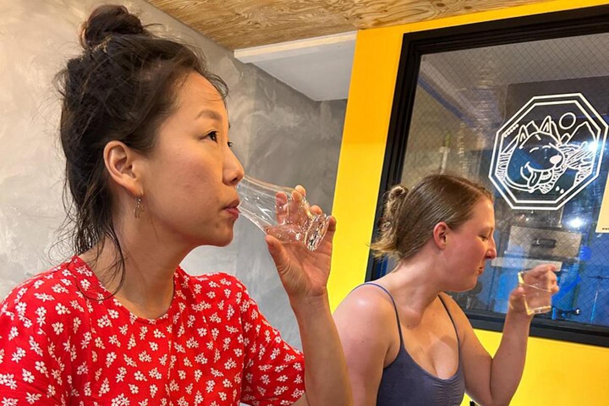two women drinking water from wine glasses