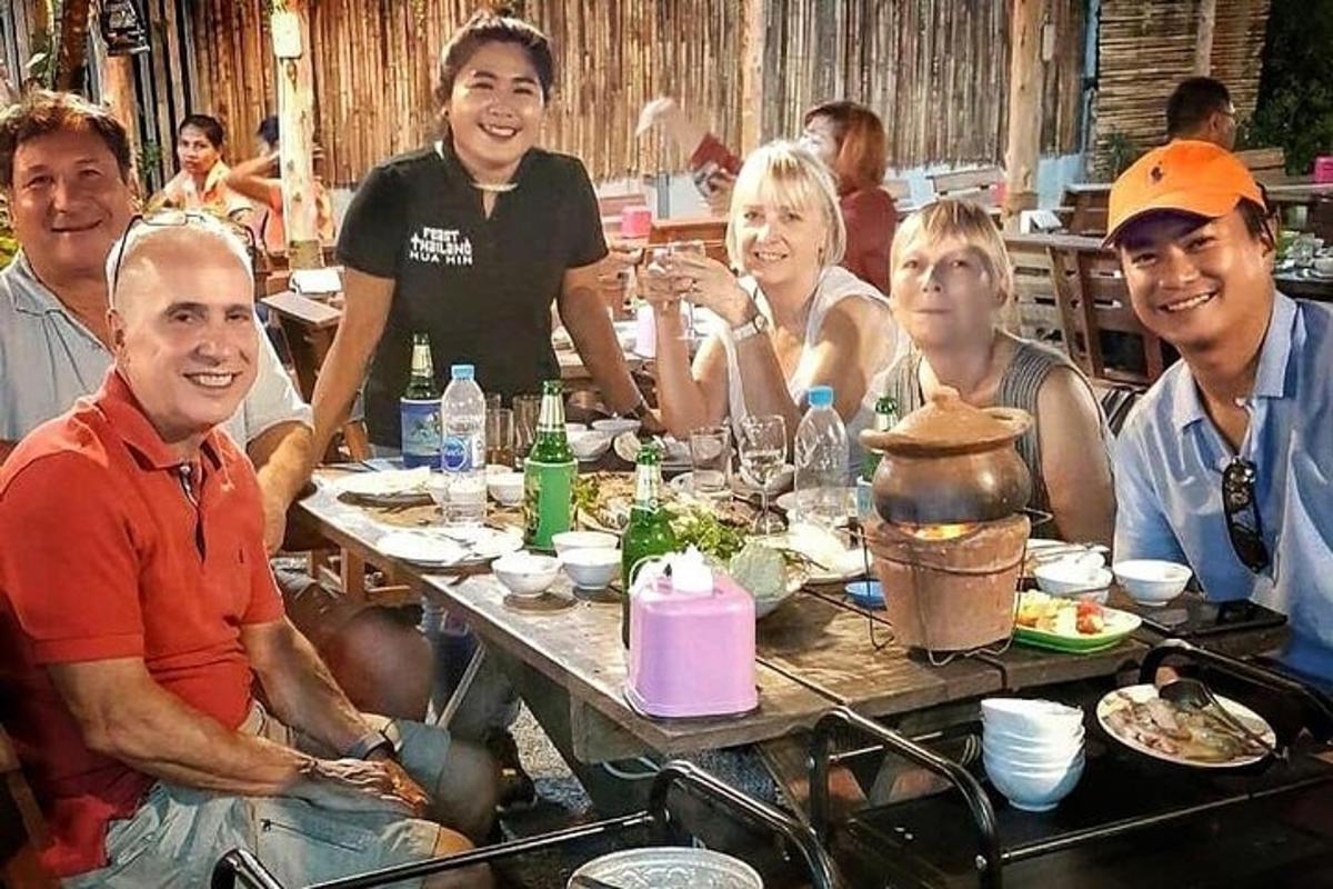 a group of people sitting around a table with food