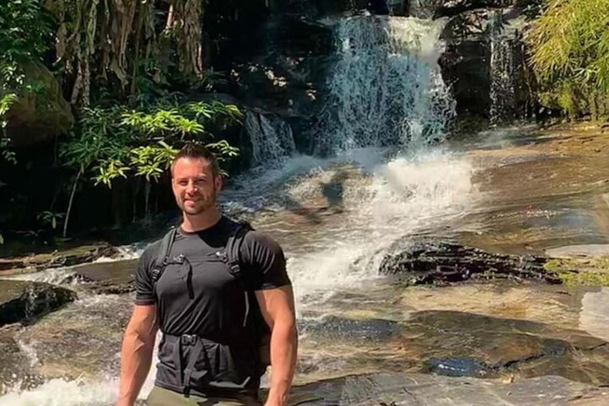 a man standing in front of a waterfall