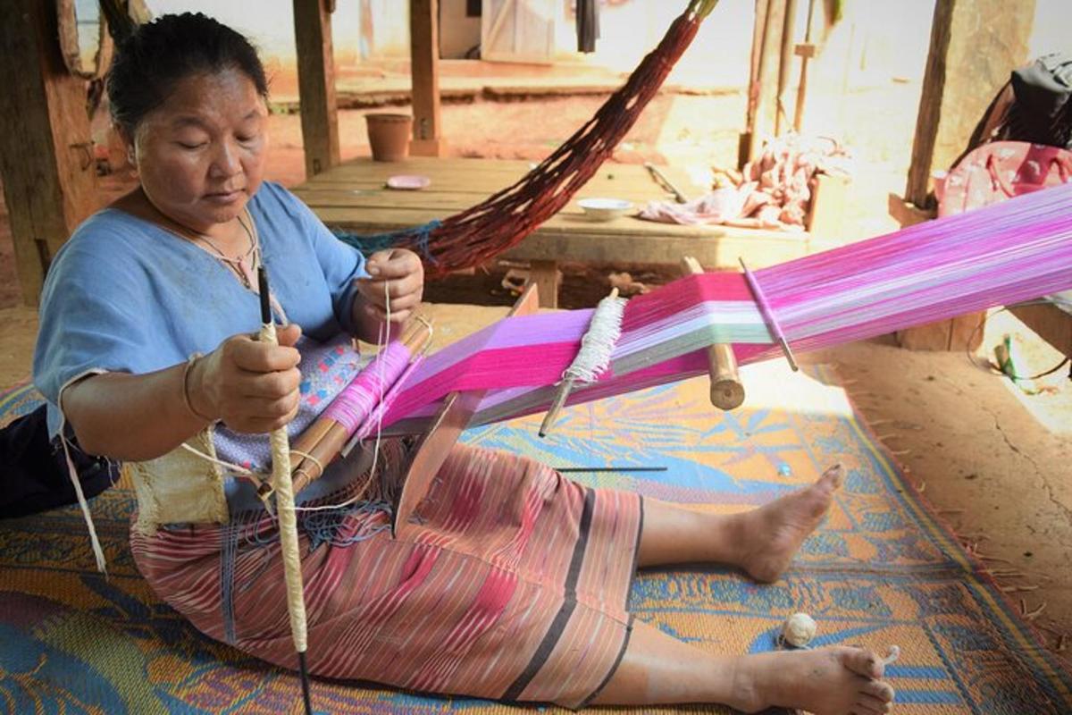 a woman sitting on the floor working on a kite