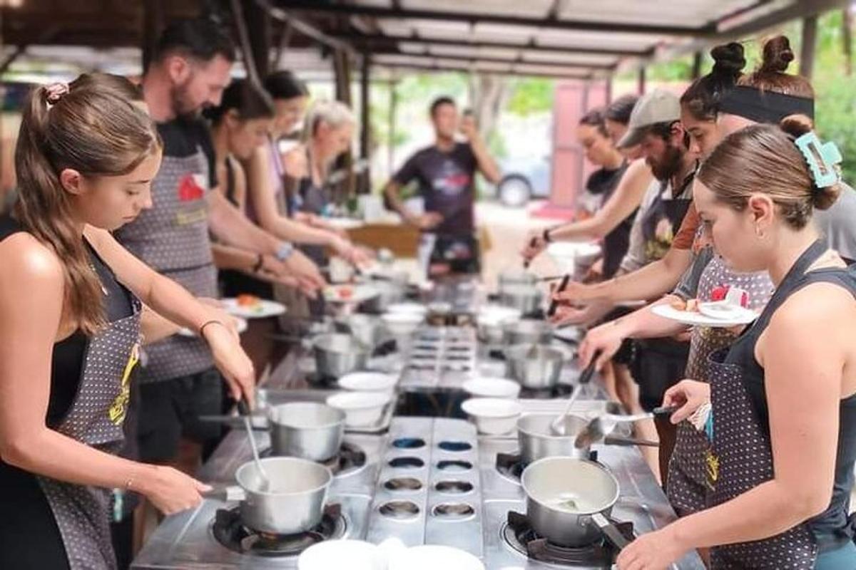 un gruppo di persone in piedi attorno a un tavolo che prepara il cibo