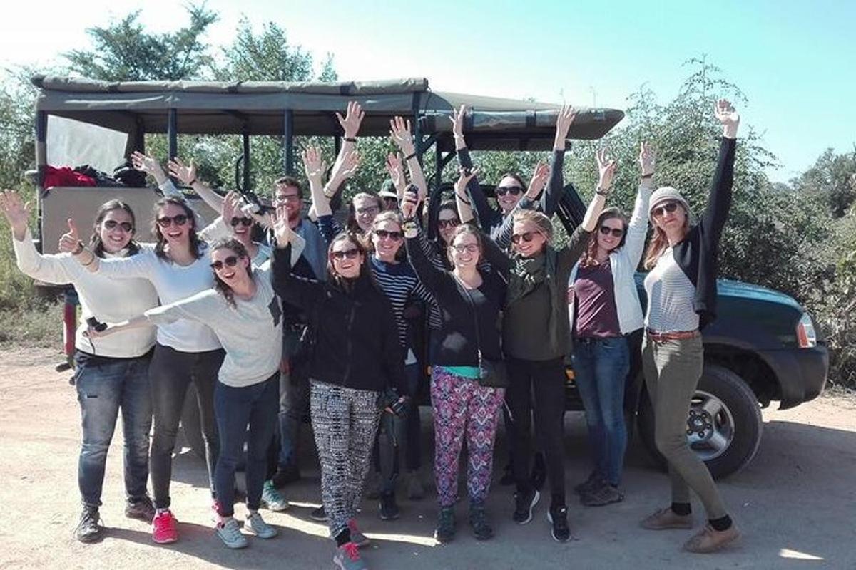 a group of people standing in front of a bus