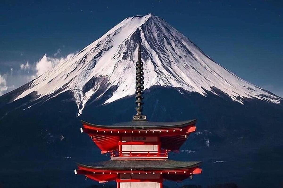 una montagna innevata con una pagoda di fronte