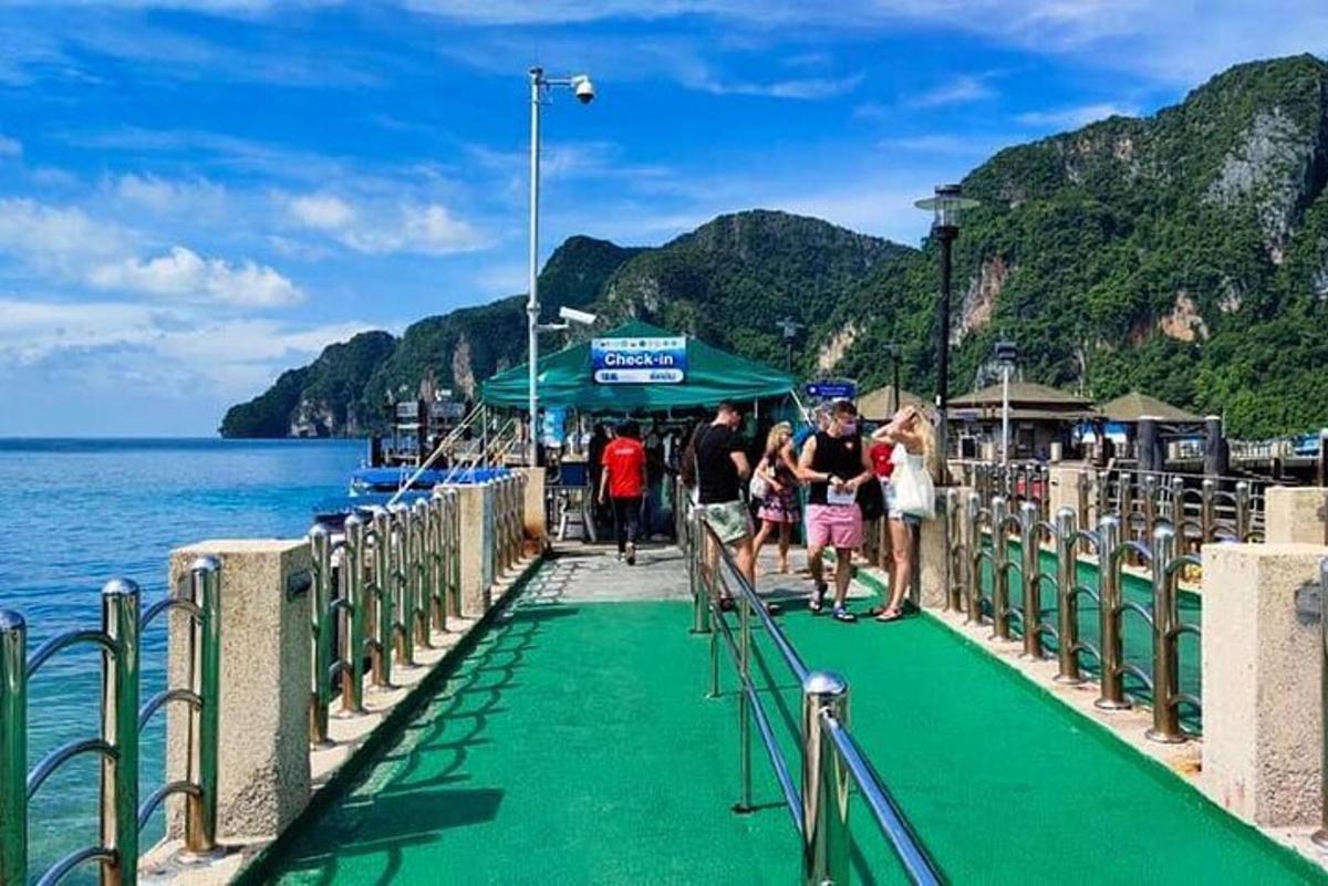 un grup de persones caminant per un moll a prop de l'aigua