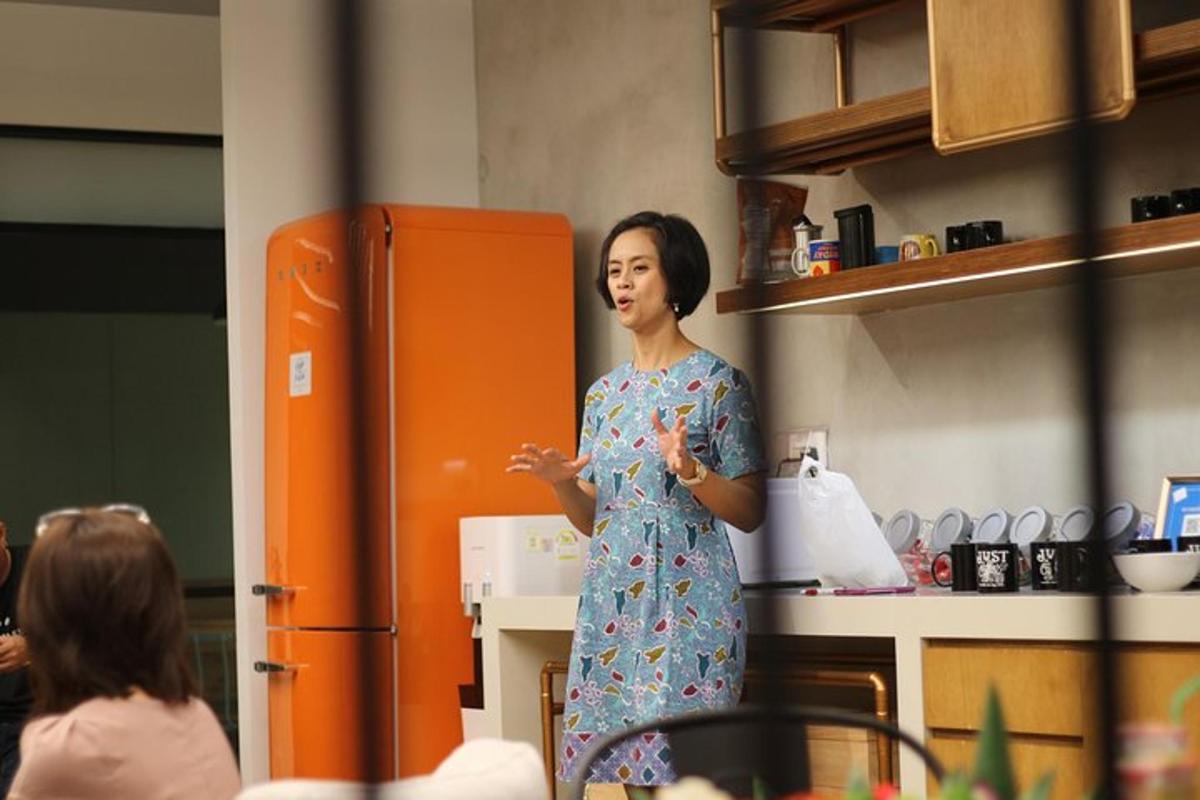una donna in piedi in cucina che parla con la gente