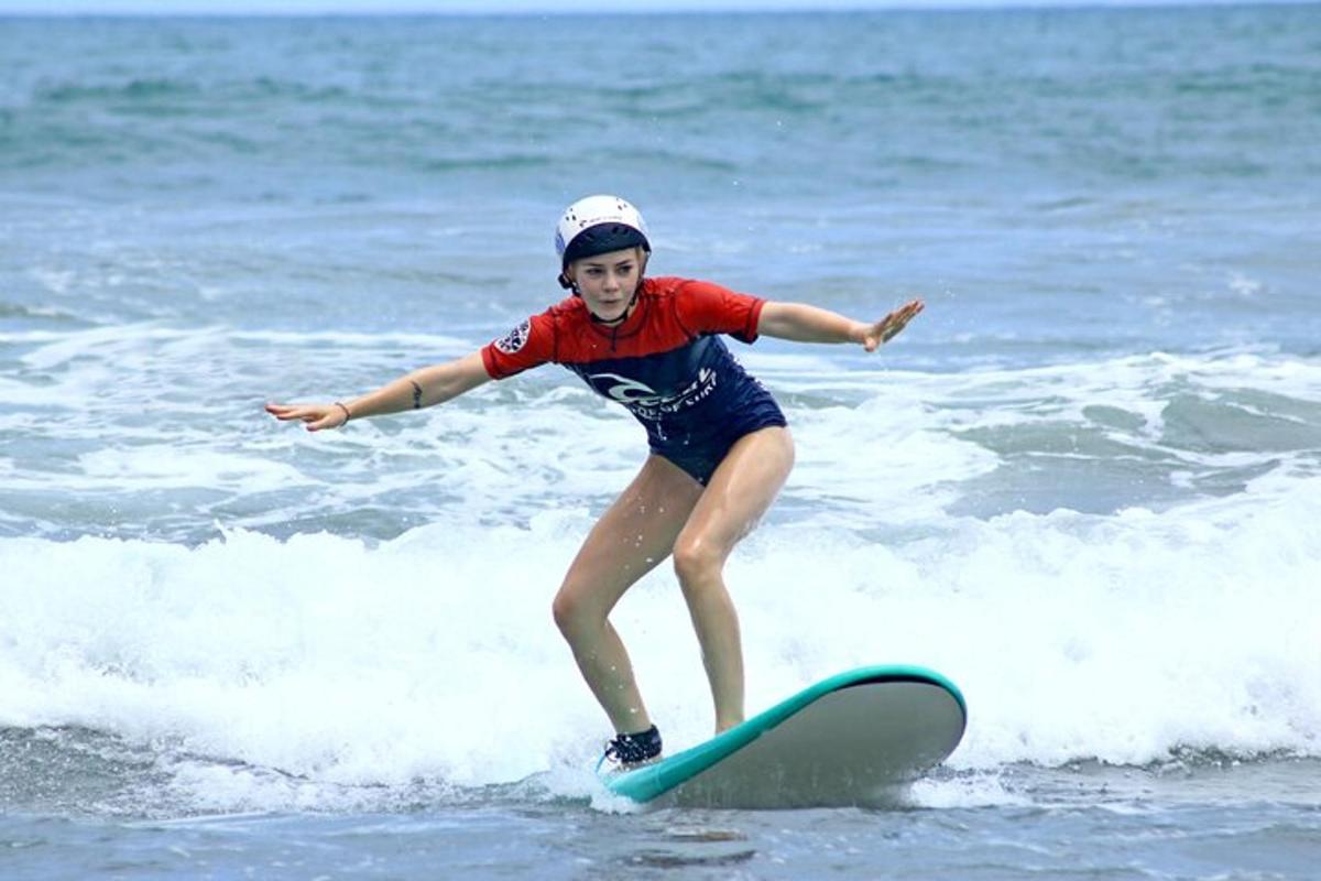 una giovane ragazza che cavalca un'onda su una tavola da surf nell'oceano