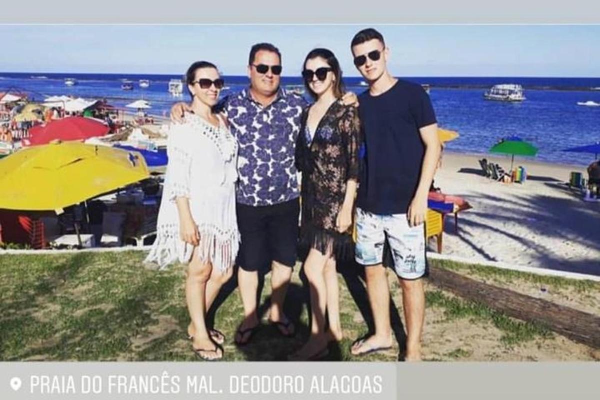 a group of people posing for a picture at the beach
