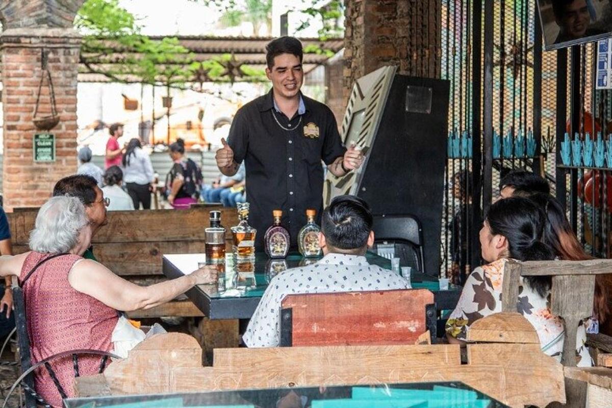 um homem fazendo uma apresentação em um restaurante com pessoas sentadas à mesa