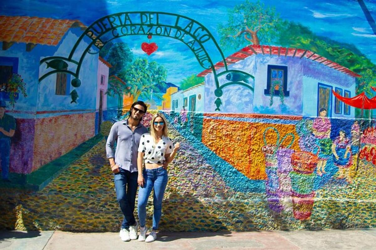 um homem e uma mulher em pé em frente a um mural