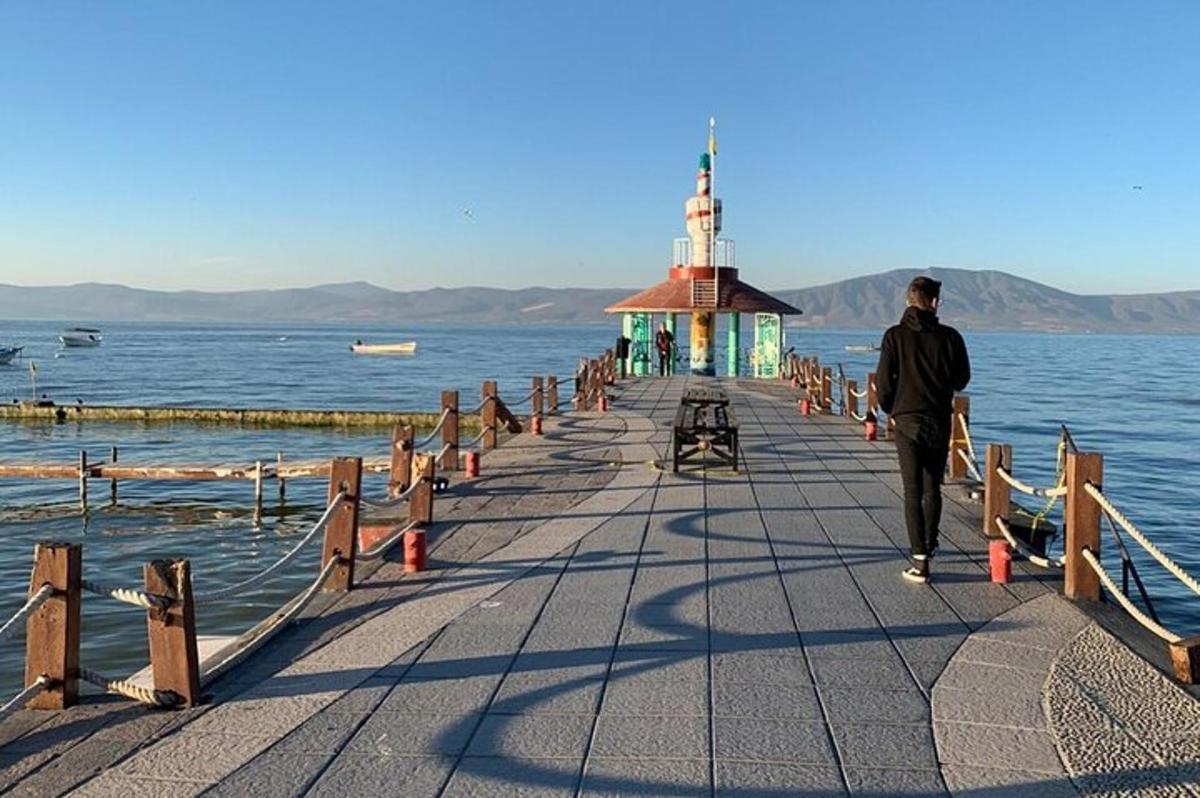 um homem caminhando em uma doca na água
