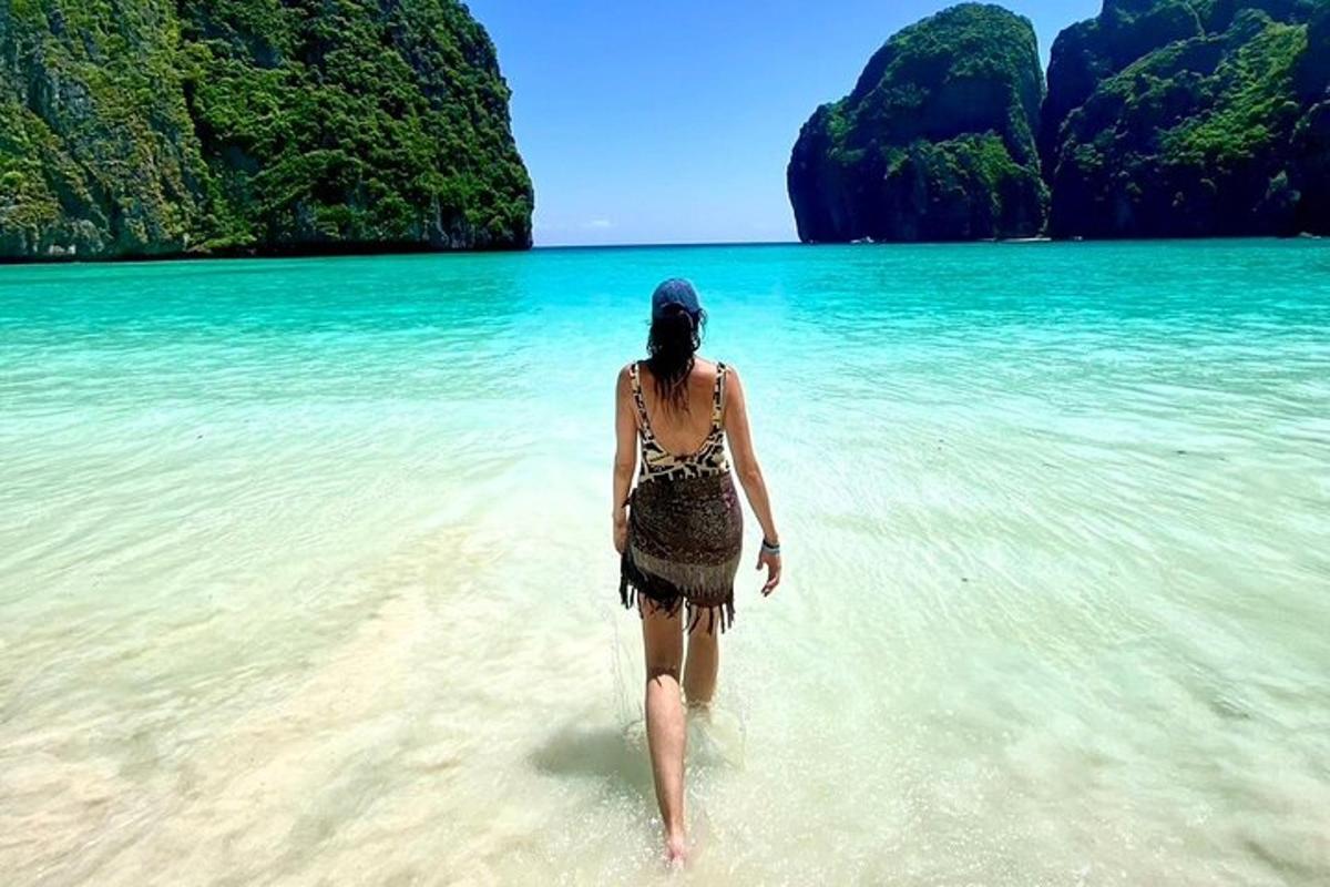 một người phụ nữ đang đi bộ trên bãi biển trong nước