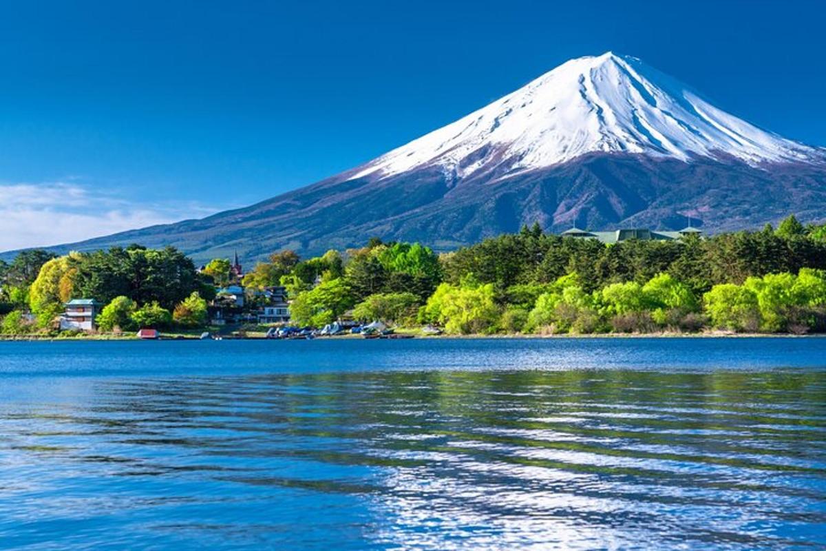 a snow covered mountain sitting next to a body of water