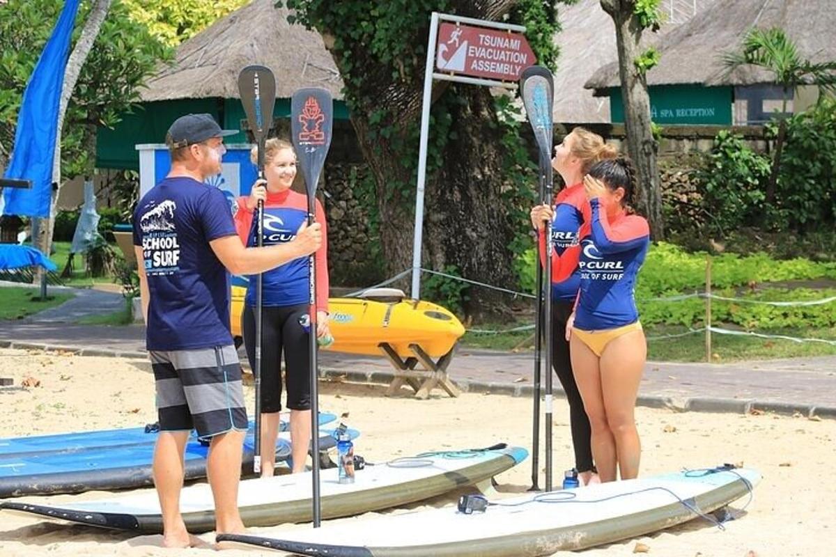 sekumpulan orang berdiri di atas papan luncur di pantai
