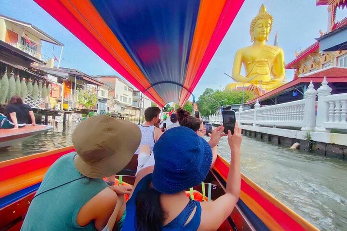 กลุ่มคนกำลังถ่ายรูปพระพุทธรูปบนเรือ