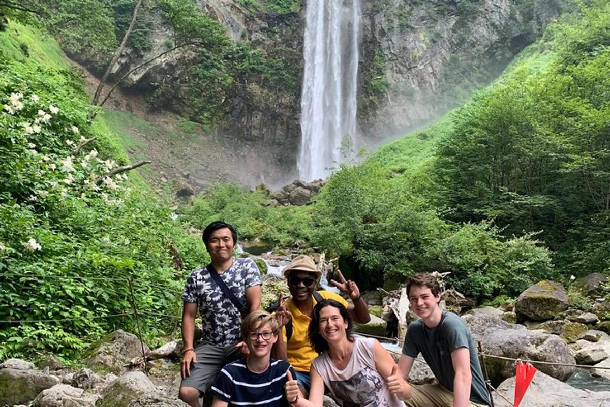a group of people posing in front of a waterfall