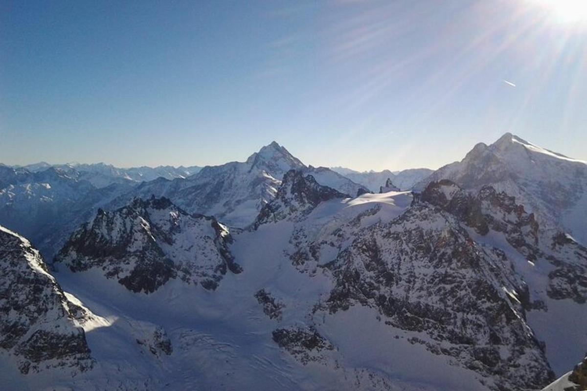 utsikt over en snødekt fjellkjede med solen