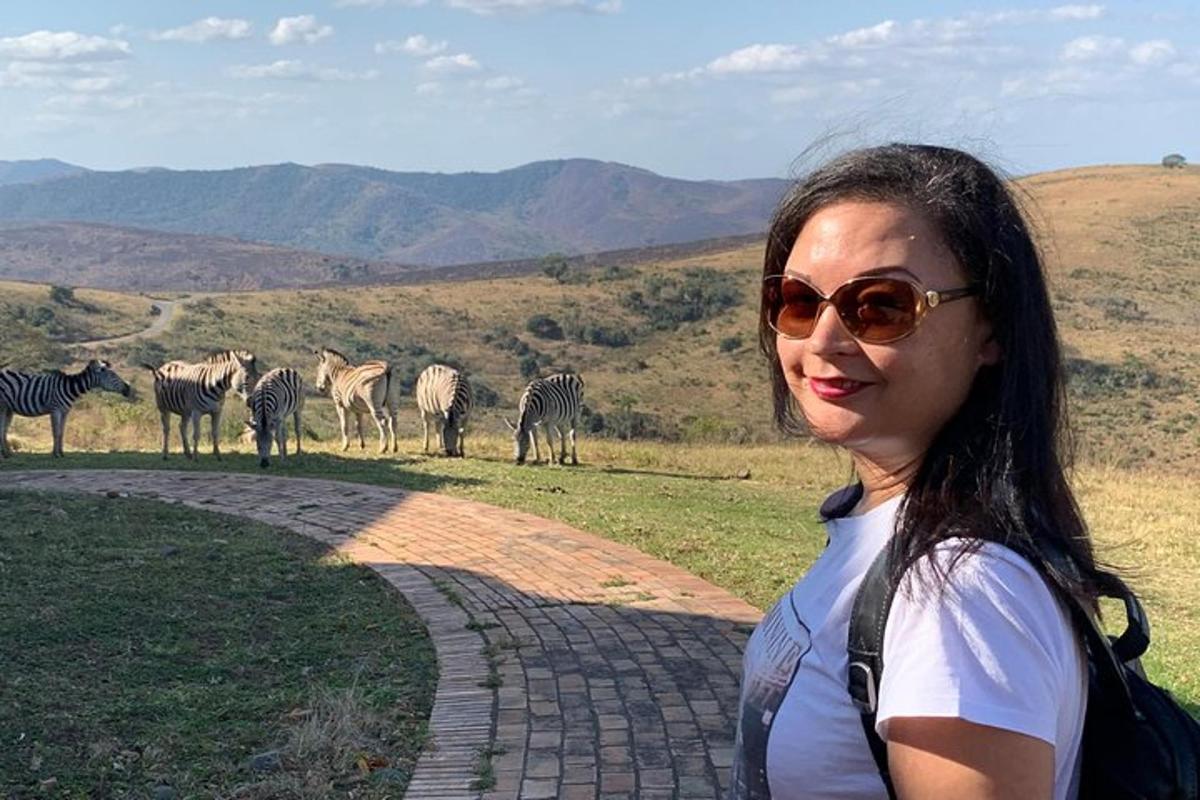 una donna in piedi davanti a una mandria di zebre